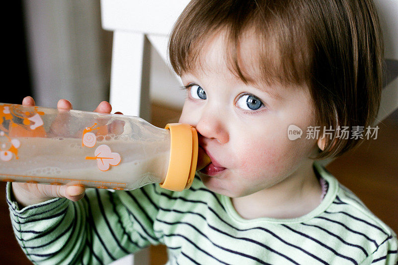 一个小婴儿在用奶瓶喝水