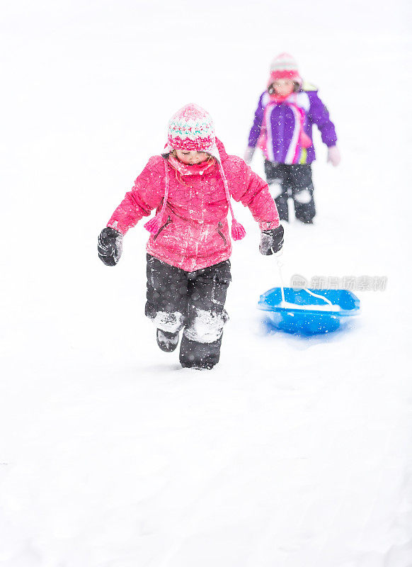 女孩们在暴风雪中玩雪橇