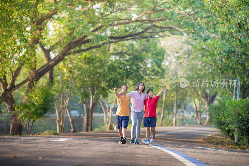 家庭运动快乐活跃的母亲和孩子在户外慢跑，在森林里跑步