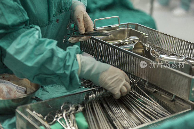 外科医生在手术过程中从金属架上取下工具