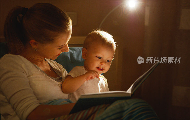 妈妈在床上给婴儿读书