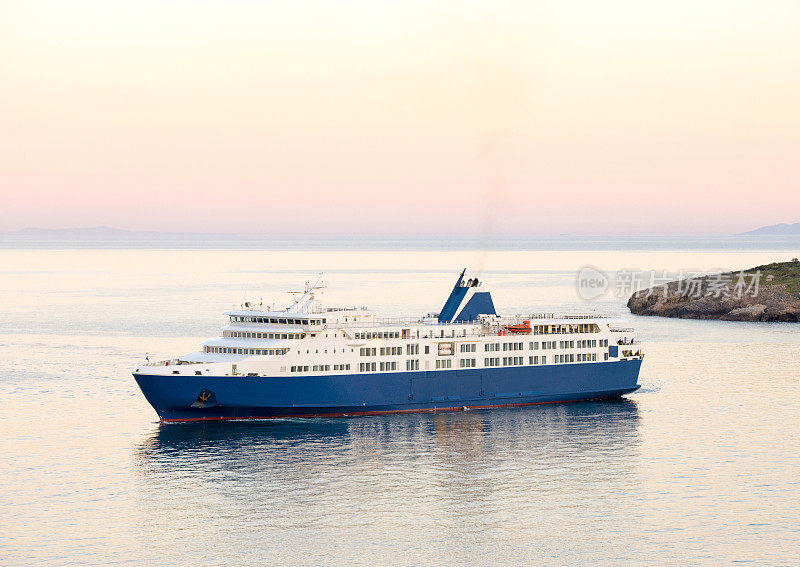 夕阳和希腊群岛上的蓝白渡船