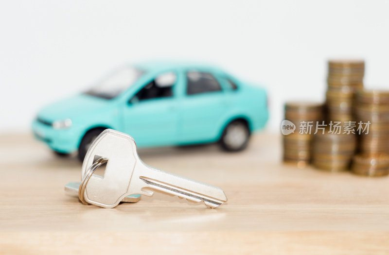 硬币与一辆蓝色的模型车和钥匙。贷款融资的概念。