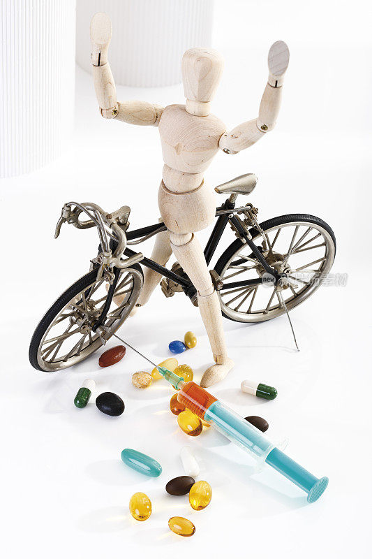 木制小雕像骑赛车，在前景药丸和注射器