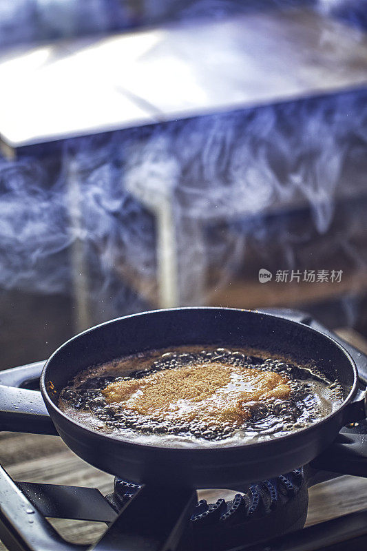 用平底锅在深油中煎炸维也纳炸肉排