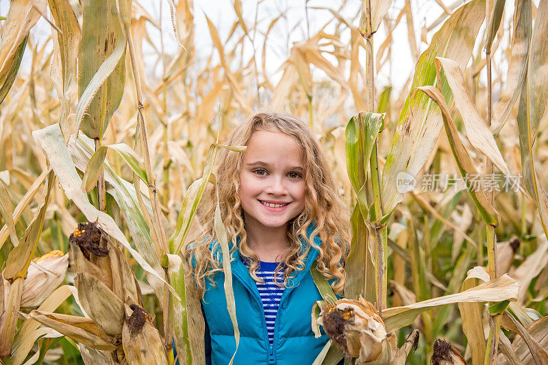 年轻女孩站在玉米地里对着镜头微笑
