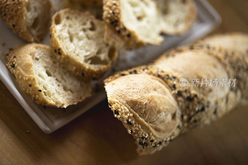 特写切片法棍面包，面包皮上有芝麻。