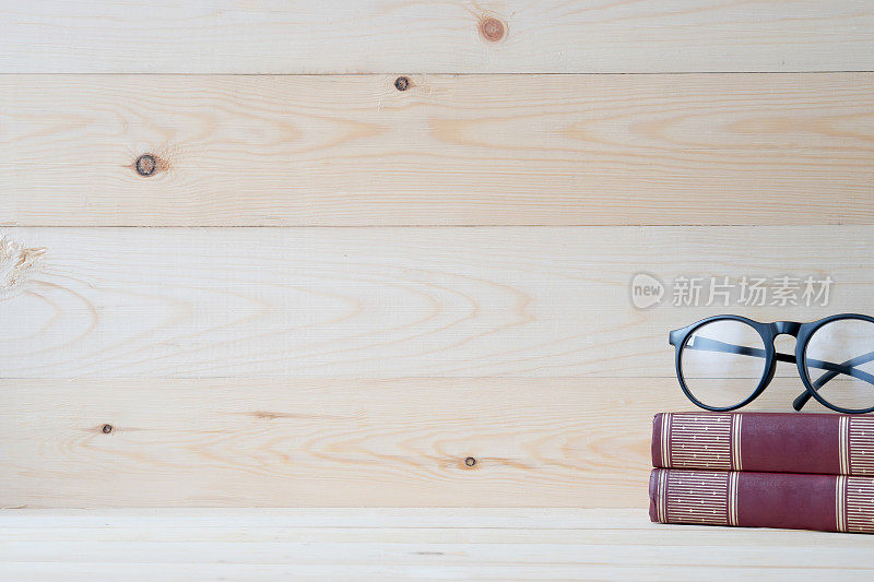眼镜和书在木头桌子上