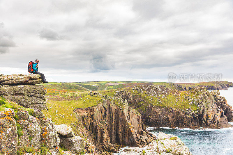一个人坐在悬崖峭壁上欣赏风景