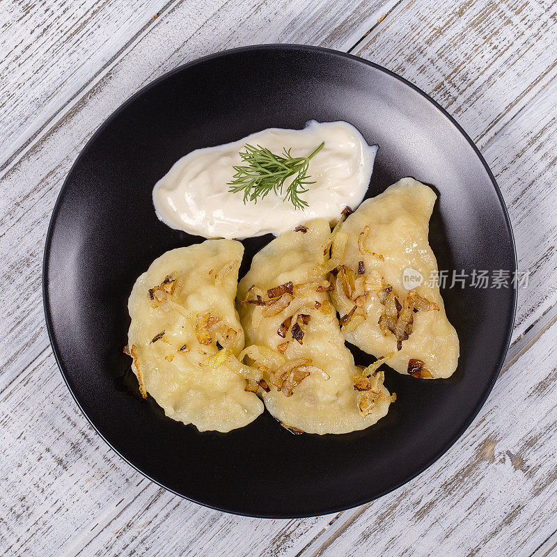 乌克兰和俄罗斯菜vareniki配土豆，炸洋葱和酸奶油。