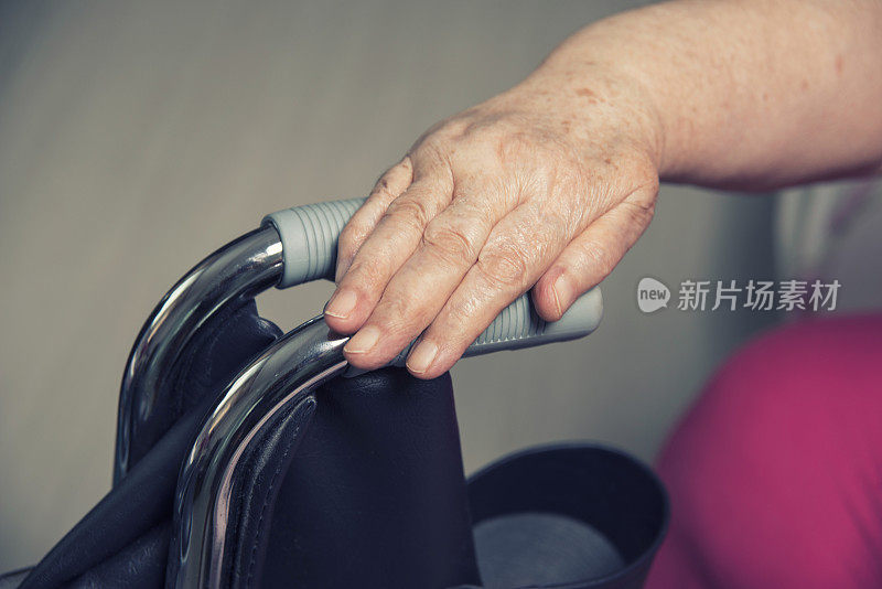 年长妇女的手与轮椅