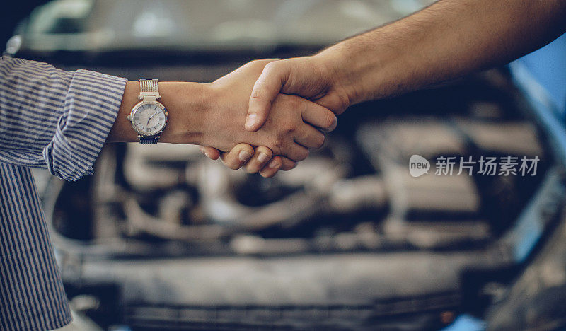 女人和汽车修理工握手
