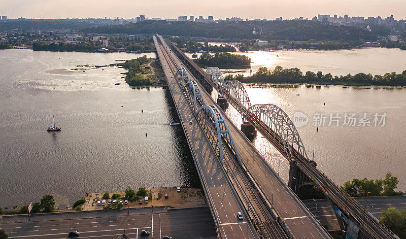 从上空俯瞰横跨第聂伯河的汽车和铁路达尔尼茨基桥，基辅市日落天际线，乌克兰