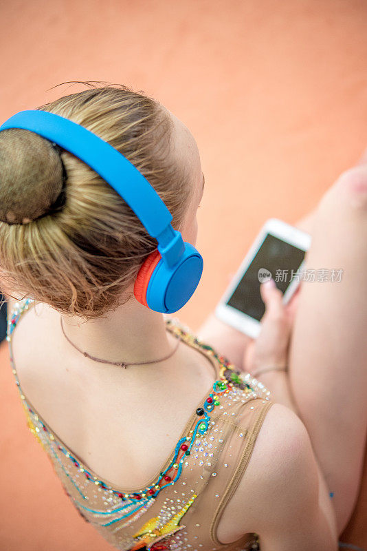 青少年艺术体操运动员用耳机听音乐