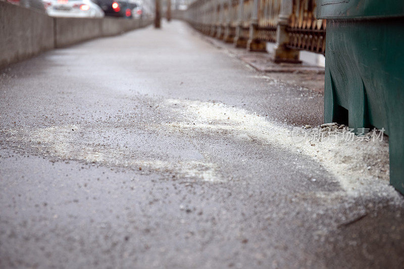 盐洒在人行道上。抽象的季节背景