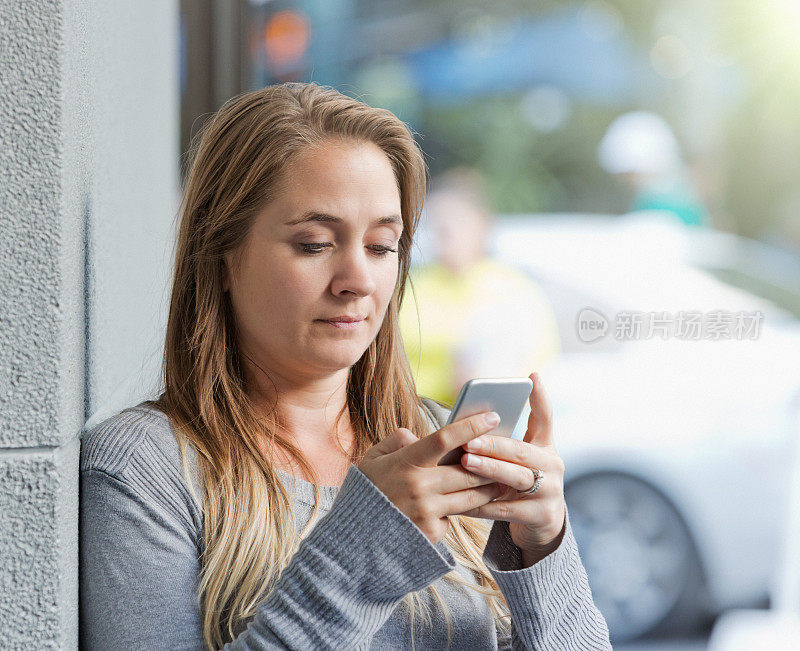 站在旁边用手机发短信的女人