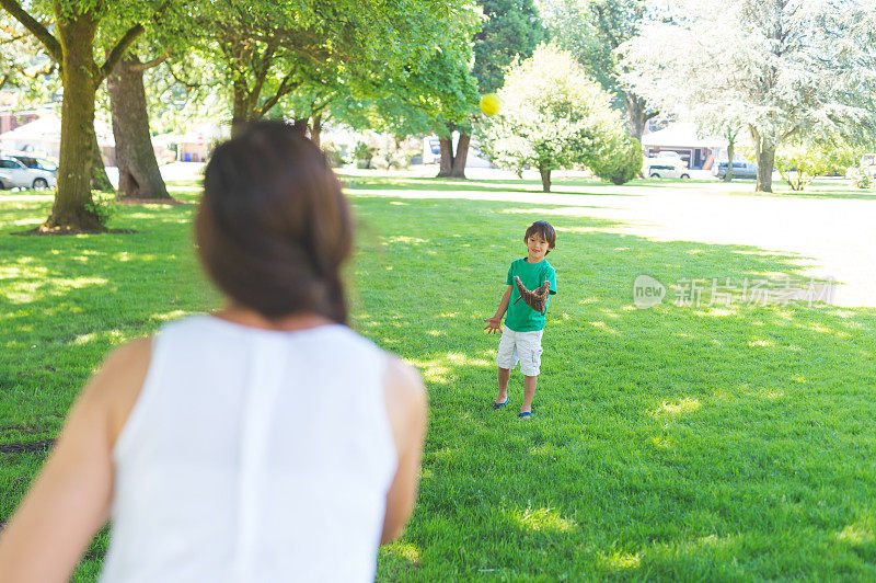 妈妈和她的儿子在公园玩接球