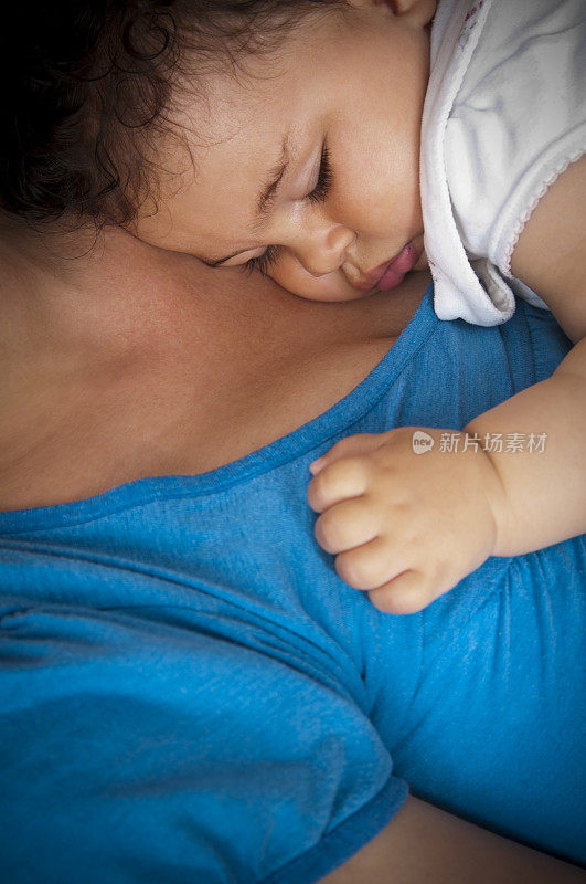 婴儿(8个月)睡在妈妈的肩膀上
