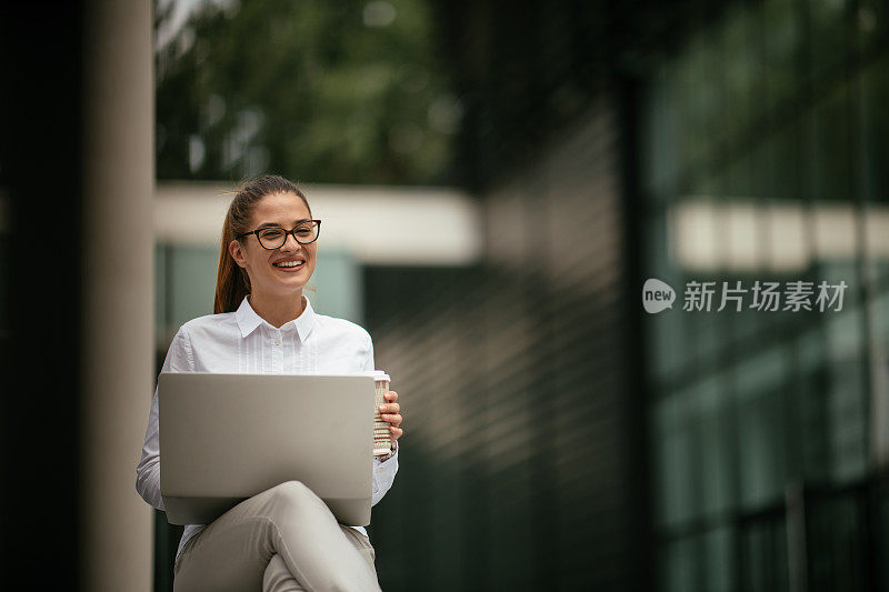 年轻漂亮的女商人一边打电话一边喝咖啡