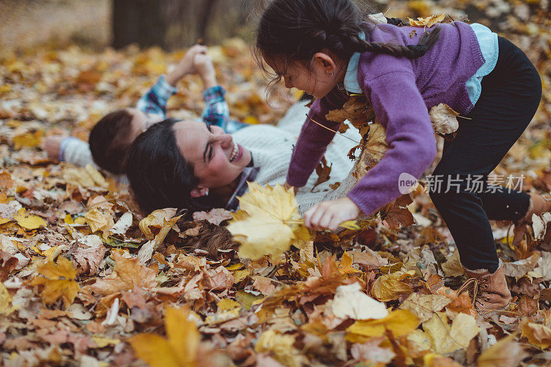 母亲和她的儿子和女儿在秋天公园