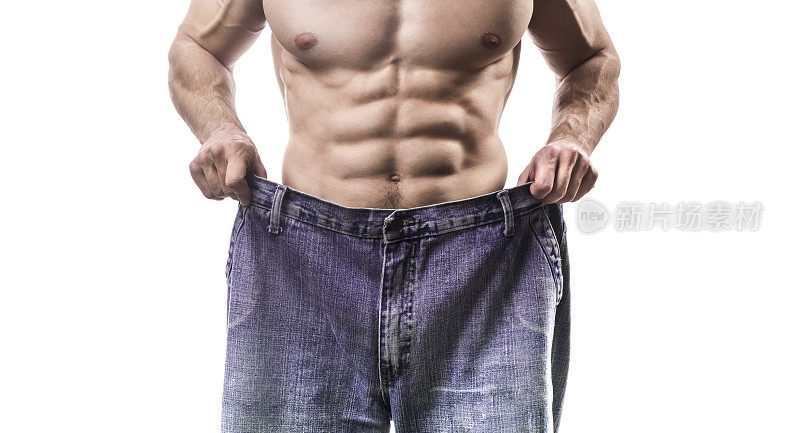体重减轻，肌肉发达的男子穿着太大的牛仔裤孤立在白色背景的特写