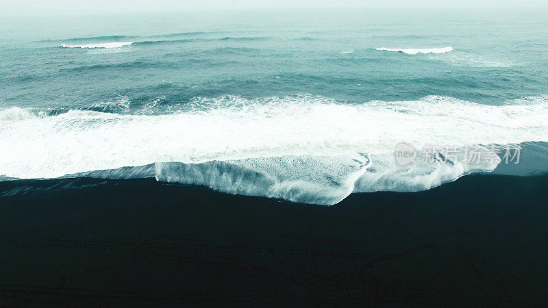 黑色沙滩上无休止的海浪