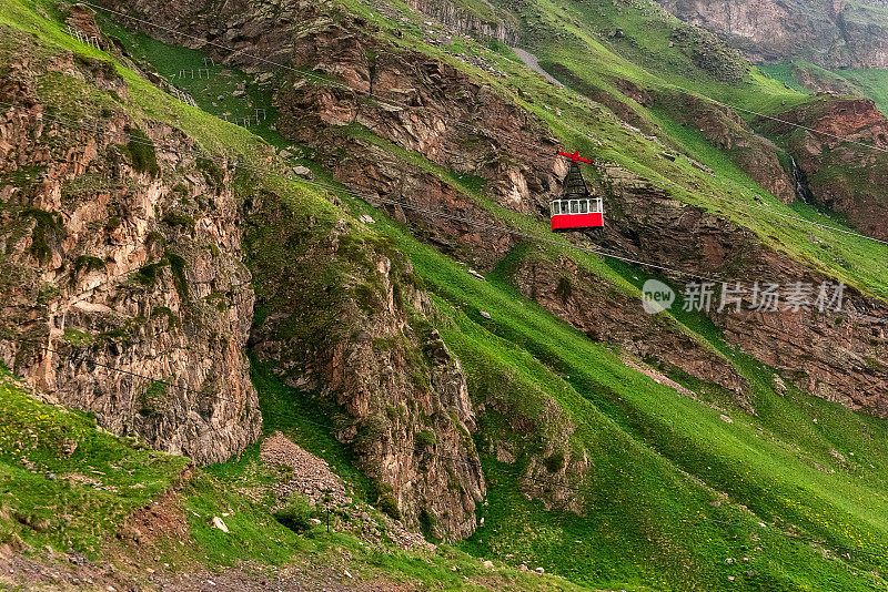 高加索山脉的索道。红色的缆车沿铁缆向下移动。高加索美丽的山景。