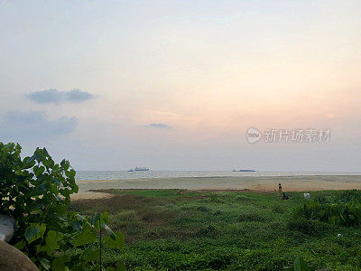 mage的热带海滨海岸和海岸线棕榈树的剪影，日落在果阿海滩海边在冬季日落，Palolem，南果阿，印度，度假，橙色的日落倒影照片，拍海浪的背景