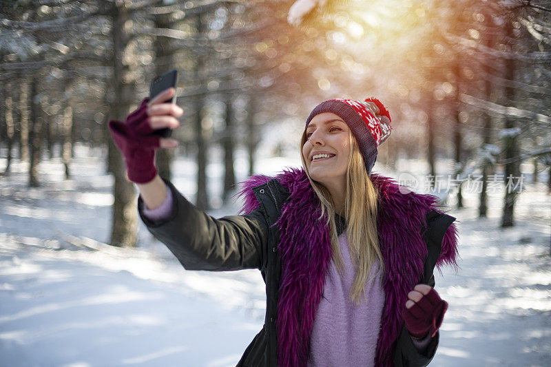 可爱的女人在雪域森林里自拍