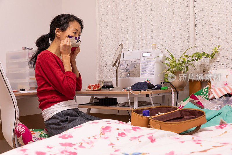 一名日本妇女在家里制作面具