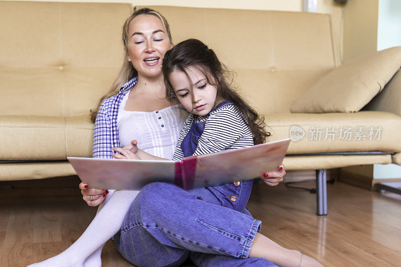 妈妈正在给女儿读一本书
