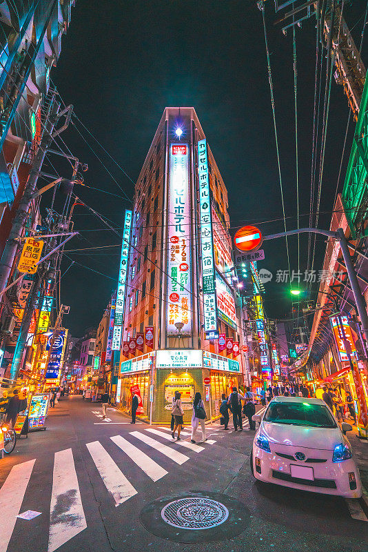 东京高峰时段的通勤者在日本新桥的街道上霓虹闪烁