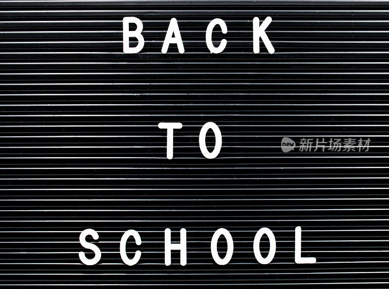 黑板上写着白色塑料字母，上面写着:回学校。