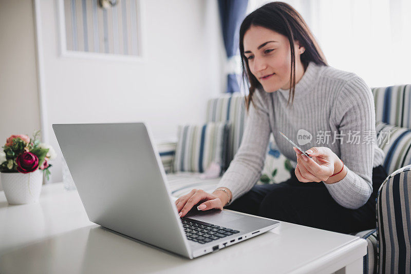 年轻女子在黑色星期五在家用信用卡购物