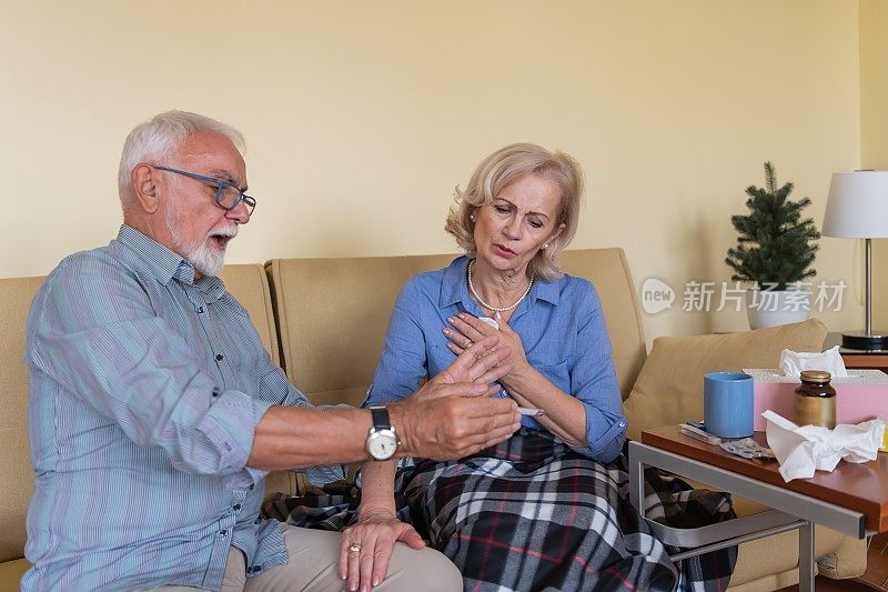 老人正在给他的妻子测体温。