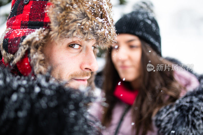 一个英俊的年轻人和他的女朋友在一个下雪的日子