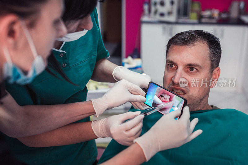 牙医检查病人的牙齿，护士通过智能手机拍摄他们