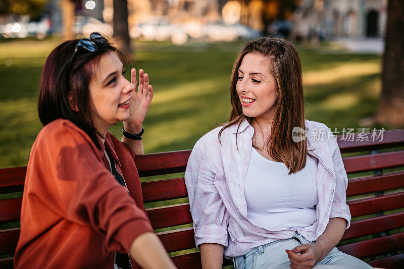 两个女人在公园长椅上聊天