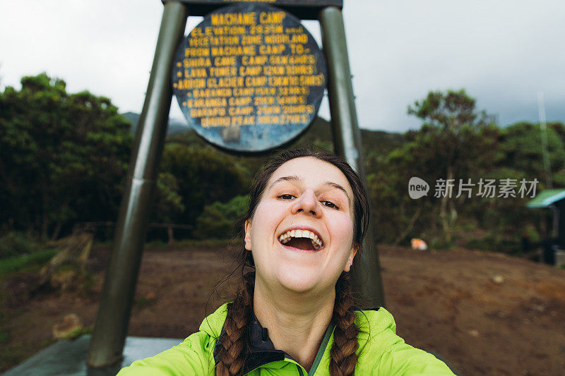 在乞力马扎罗山地区，一名年轻的徒步旅行者微笑着自拍前往营地