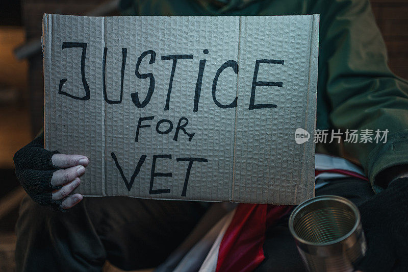 退伍军人在街上乞讨，手里举着一个写着“兽医正义”的牌子