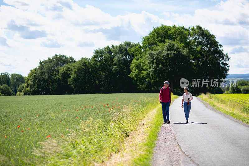 老年人在乡村道路上徒步旅行