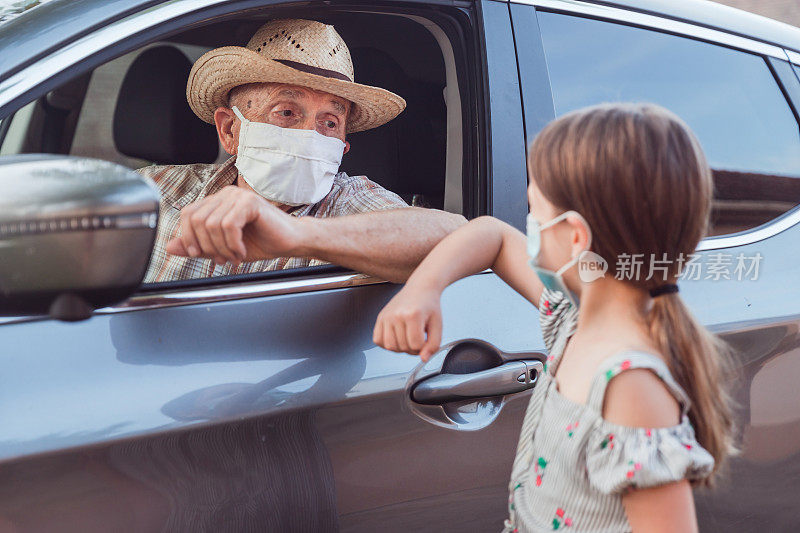 老人戴着防护面具从车上跟女儿说再见