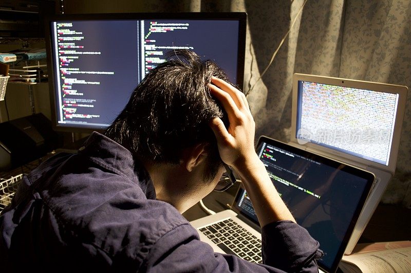 一个年轻的亚洲程序员在做编程，在他的黑房间里如何写代码是一个麻烦