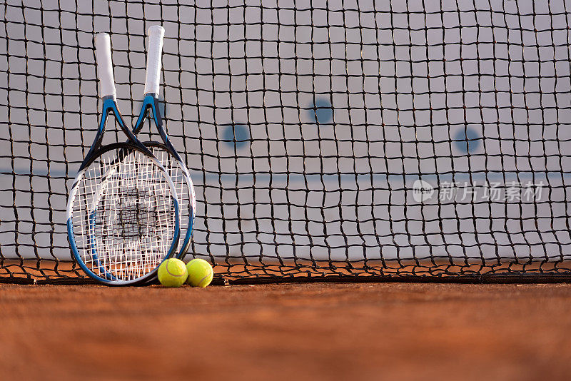 网球拍和球靠在网上。