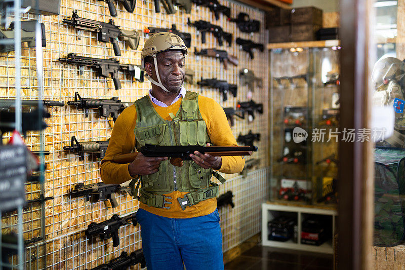 非裔美国人穿着军装拿着武器在军事商店