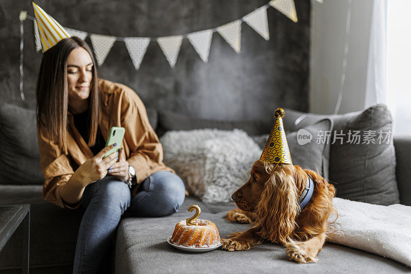 快乐的女人在家里和她的狗狗庆祝她的狗生日。