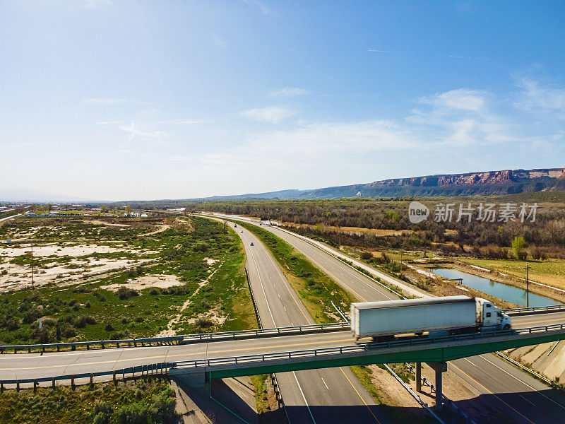 在美国西部70号州际公路和立交桥上驾驶的车辆和半卡车的无人机视图