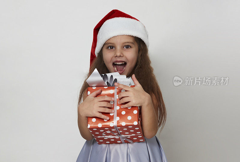可爱的女孩与白色背景的圣诞礼品盒