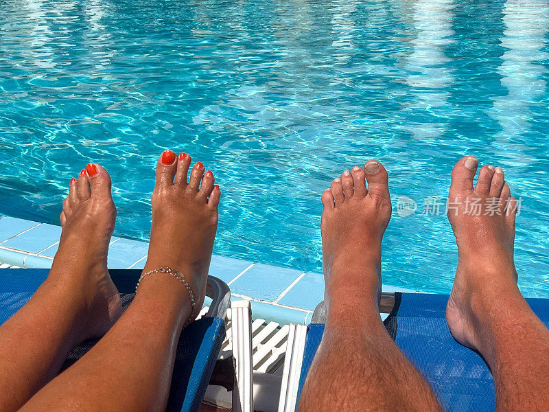 男男女女光着脚在游泳池晒太阳