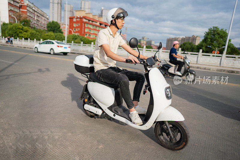 男子在城市里骑电动自行车